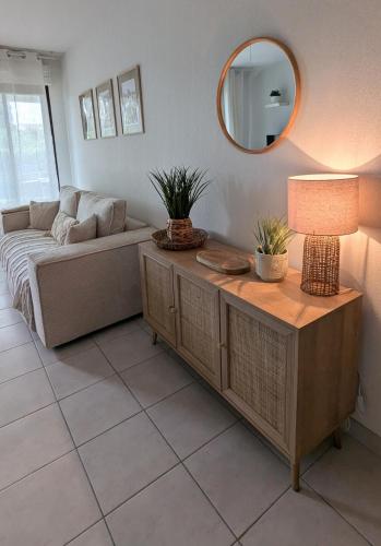 - un salon avec un canapé et une table avec une lampe dans l'établissement Joli rez de jardin piscine, à Aigues-Mortes