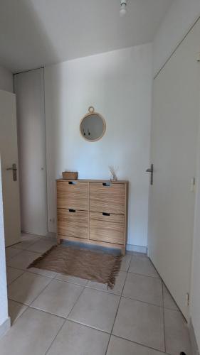 Cette chambre comprend une commode et un miroir mural. dans l'établissement Joli rez de jardin piscine, à Aigues-Mortes