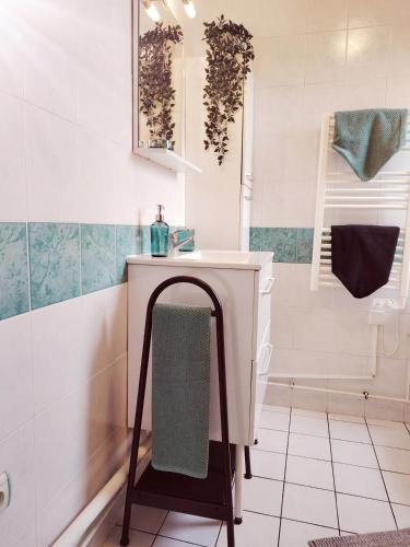 La salle de bains est pourvue d'un lavabo blanc et d'une serviette. dans l'établissement Bord de mer, au Havre