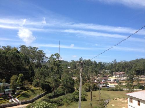 a view of a town with a telephone pole at GlenBrook HomeStay in Munnar