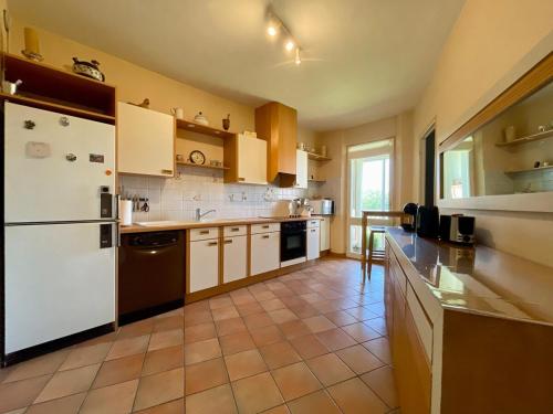 Il comprend une cuisine équipée d'un réfrigérateur blanc. dans l'établissement Le Vintage des Oliviers - Vue Aude ascenseur et parking, à Carcassonne