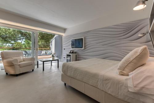 a bedroom with a bed and a chair at Augustus Hotel & Resort in Forte dei Marmi