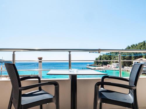 a table and chairs on a balcony with a view of the ocean at Endless Blue Himara in Himare