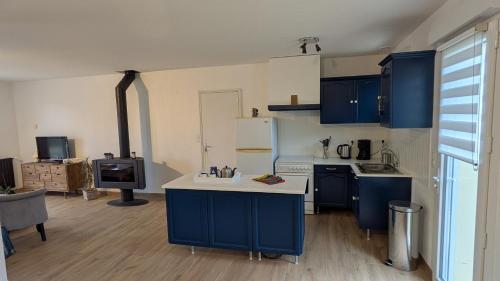 a kitchen with blue cabinets and a white counter top at Le gîte "Guiste" in Cléder