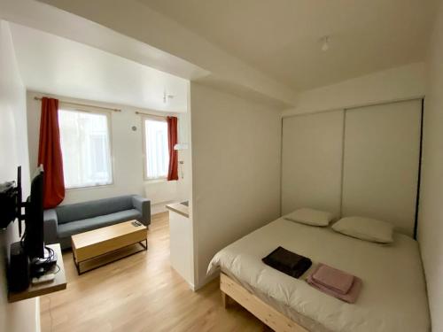une petite chambre avec un lit et un canapé dans l'établissement Heart of Rouen, à Rouen