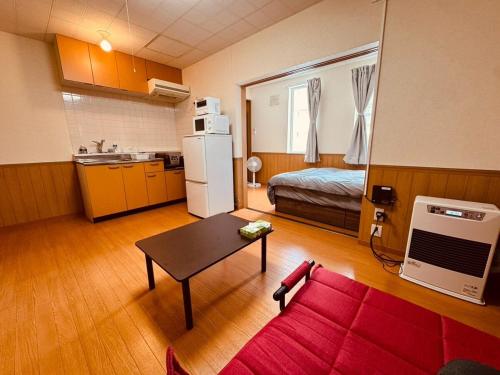 a living room with a red couch and a kitchen at Choyo 103 in Sapporo