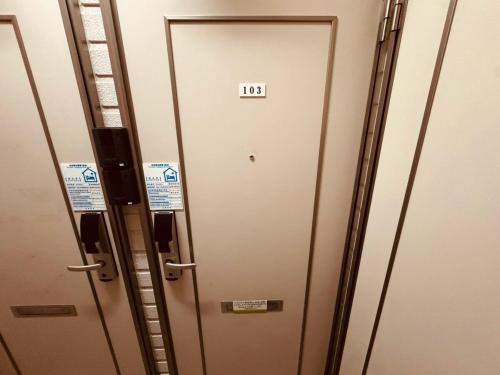 a row of elevator doors with a sign on them at Choyo 103 in Sapporo