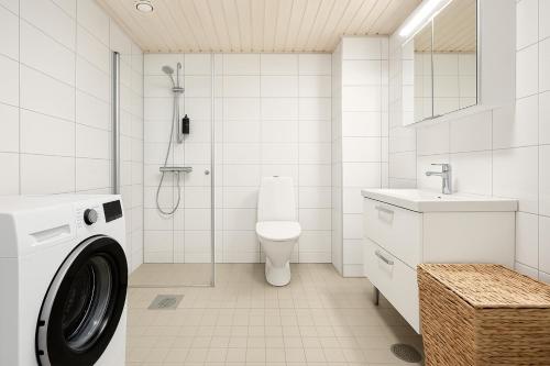 a bathroom with a washing machine and a toilet at Tammer Huoneistot - City Suite 6 - Best Location & Great Amenities in Tampere