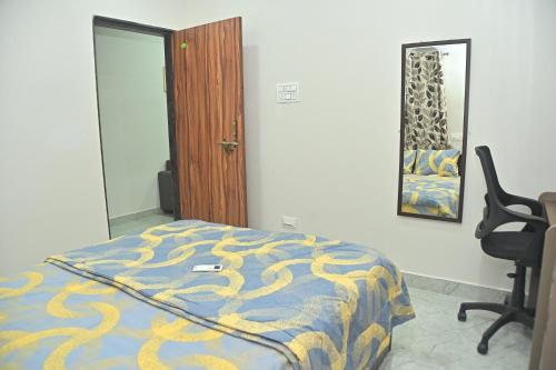een slaapkamer met een bed, een stoel en een spiegel bij AVO Nest Kondapur - 1 BHK Fully Furnished Penthouse #601 in Kondapur