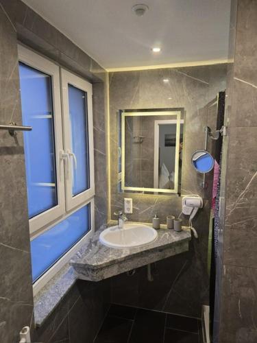 a bathroom with a sink and a window at Bodensee Sunshine Zimmer & Apts. in Uhldingen-Mühlhofen