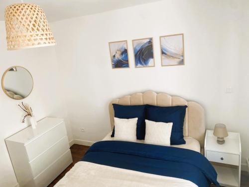 une chambre avec un lit avec des draps bleus et un miroir dans l'établissement Charming apartment in Nancy city center, à Nancy
