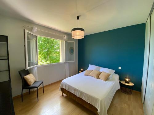 une chambre avec un lit et un mur bleu dans l'établissement Gîte de Pech de Monfabes, à Villeneuve-sur-Lot