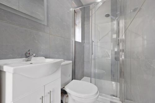 a bathroom with a toilet and a sink and a shower at South Harrow Apartment in London
