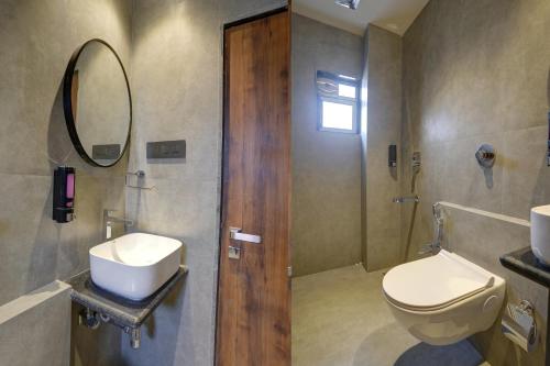 a bathroom with a toilet and a sink and a mirror at Starville Hotel Andheri MIDC in Mumbai