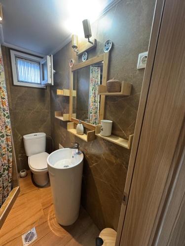 a bathroom with a sink and a toilet and a mirror at Ana Maria Boutique House in Samothraki