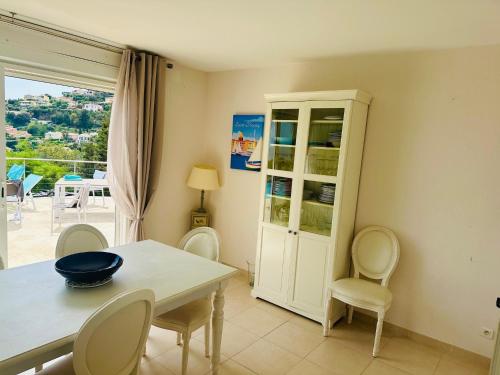 une salle à manger avec une table et des chaises et une fenêtre dans l'établissement new! Villa vue mer panoramique proche plages Saint-Tropez calme parking facile piscine privee individuelle, à Cavalaire-sur-Mer