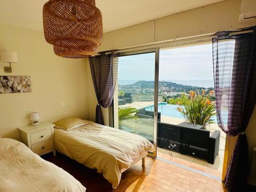 - une chambre avec un lit et une grande fenêtre avec vue dans l'établissement new! Villa vue mer panoramique proche plages Saint-Tropez calme parking facile piscine privee individuelle, à Cavalaire-sur-Mer