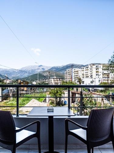 a table and two chairs on a balcony with a view at Endless Blue Himara in Himare