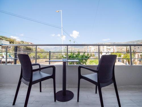 two chairs and a table on a balcony with a view at Endless Blue Himara in Himare