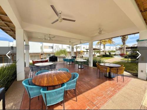 un patio con mesas y sillas y un sofá en Casa Privada Almarena, en Mazatlán