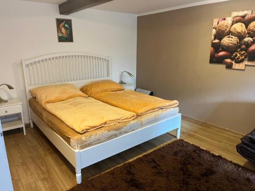 a bedroom with a bed with yellow sheets on it at Penzion Marcipánka in Třeboň