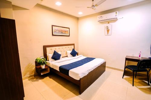 ウダイプールにあるHotel P K excellencyのベッドルーム1室(ベッド1台、デスク、椅子付)