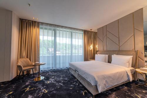 a hotel room with a large bed and a window at Elania Resort & Spa in Cluj-Napoca