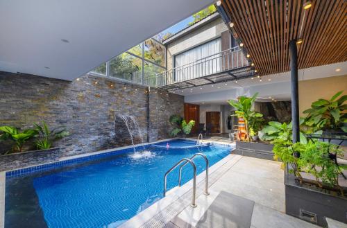 a large swimming pool in a building with a large window at Hese Boutique Hotel & Apartment in Vung Tau
