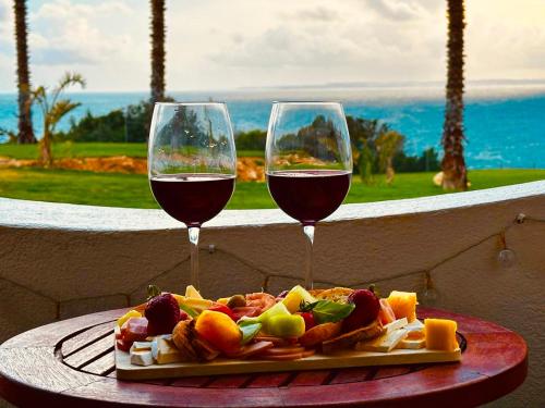 a plate of food and two glasses of wine at Luisela Mar Algarve in Carvoeiro