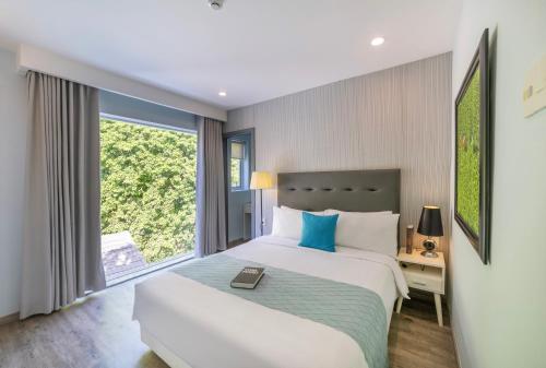 a bedroom with a large bed and a window at Hese Boutique Hotel & Apartment in Vung Tau