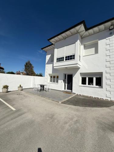 a white building with a table in a parking lot at Casa Peña in Hinojedo