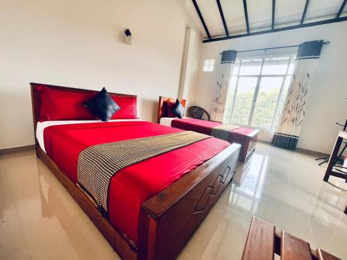 a bedroom with a large bed with a red blanket at Springvalley Holiday Home in Badulla