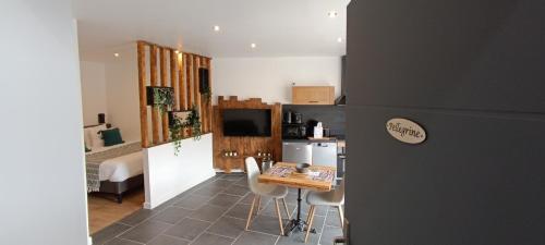 a kitchen with a small table and a kitchen with a room at L'Escapade Cévenole in Le Collet-de-Dèze