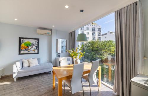 a dining room with a table and chairs and a large window at Hese Boutique Hotel & Apartment in Vung Tau