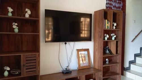 a living room with a flat screen tv on a wall at Makinihomestay in Arusha