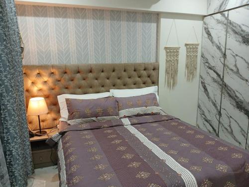 a bedroom with a bed and a table with a lamp at Lakefront Lounge-Luxe 1bhk condo with 2queen beds-2baths in Mumbai