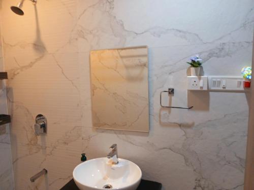 a bathroom with a sink and a mirror on a wall at Lakefront Lounge-Luxe 1bhk condo with 2queen beds-2baths in Mumbai