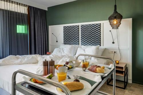 a hotel room with a tray of food on a bed at Paal 8 Hotel aan Zee in West aan Zee