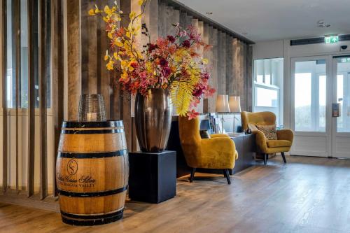 a room with a large vase with flowers in it at Paal 8 Hotel aan Zee in West aan Zee
