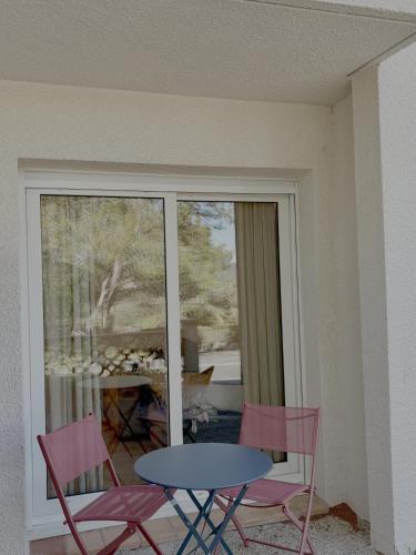 une table et des chaises dans une pièce avec une fenêtre dans l'établissement Fairway 1, à Saint-Gély-du-Fesc