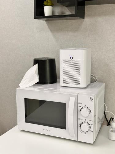 a microwave with a toaster sitting on top of it at With Hongdae in Seoul