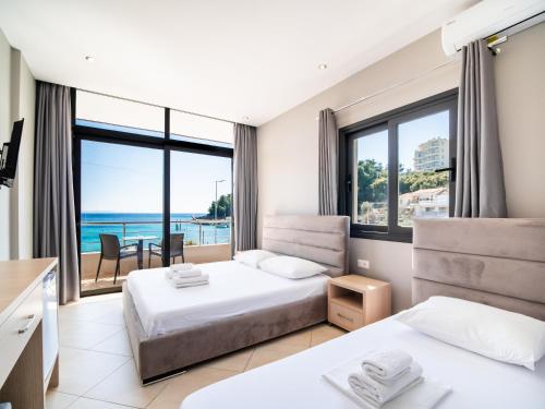 a bedroom with two beds and a view of the ocean at Endless Blue Himara in Himare
