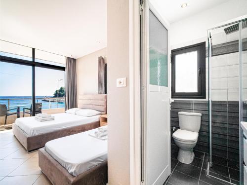 a hotel room with two beds and a shower at Endless Blue Himara in Himare