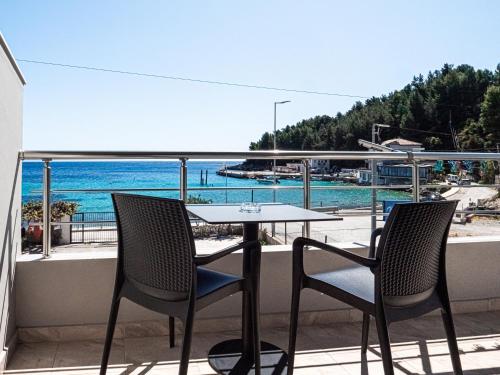 a table and chairs on a balcony with a view of the ocean at Endless Blue Himara in Himare