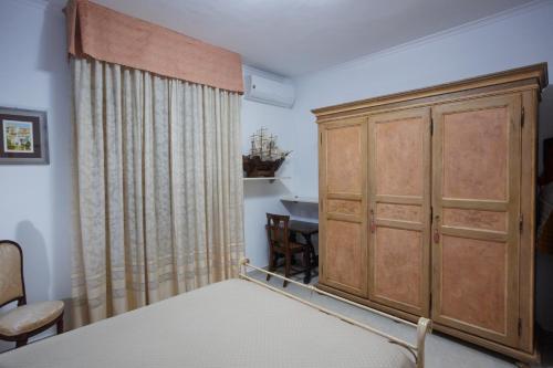 a bedroom with a bed and a wooden cabinet at The Lemon Tree House in Scalea