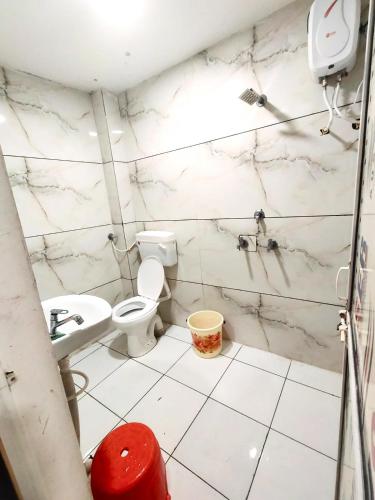 a white bathroom with a toilet and a sink at New SHIPRA TOWER in Ujjain