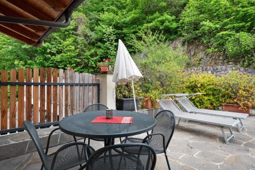 a patio with a table and chairs and an umbrella at Prackfolerhof in Fie allo Sciliar