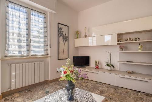 a living room with a vase of flowers on a table at Quadri d'Oro - Beachside Escape in Beautiful Liguria in Loano