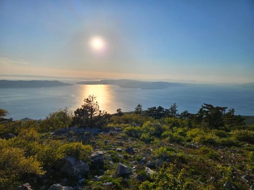 a sun setting over the ocean on top of a hill at Concha Aurea Apartments in Sveti Juraj