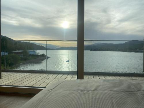 a bedroom with a view of a body of water at Villa Über-See with private beach in Pörtschach am Wörthersee